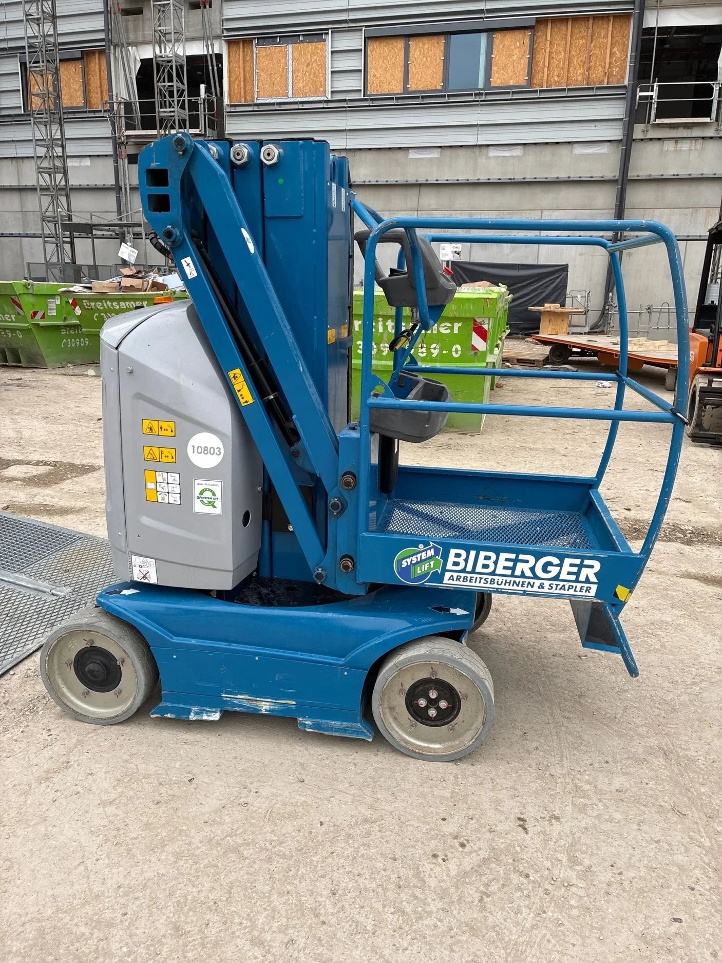 Blaue Arbeitsbühne auf Baustelle, ideal für sicheren Höhenzugang und effizientes Arbeiten.