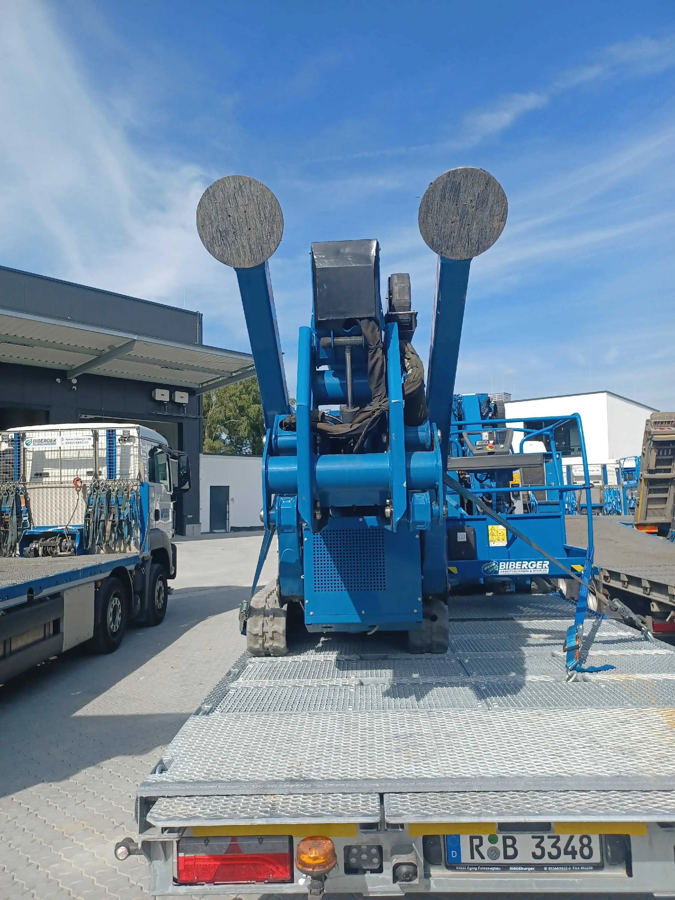 Blaue Arbeitsbühne auf LKW-Ladefläche, bereit für Baustelle – mieten oder kaufen